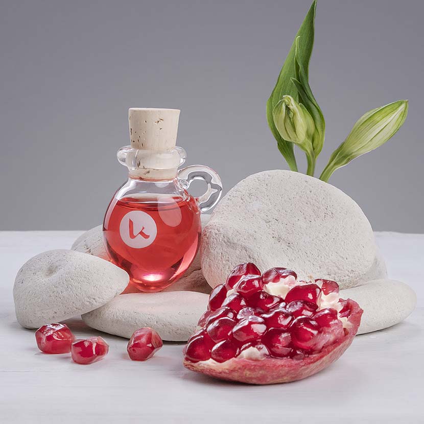 Cold-pressed pomegranate seed oil in a hand blown glass amphora